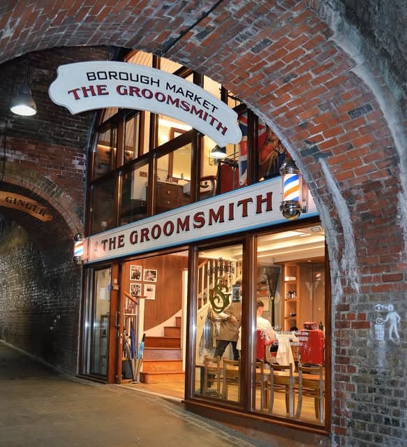 The lit shopfront under the railway arch at dusk